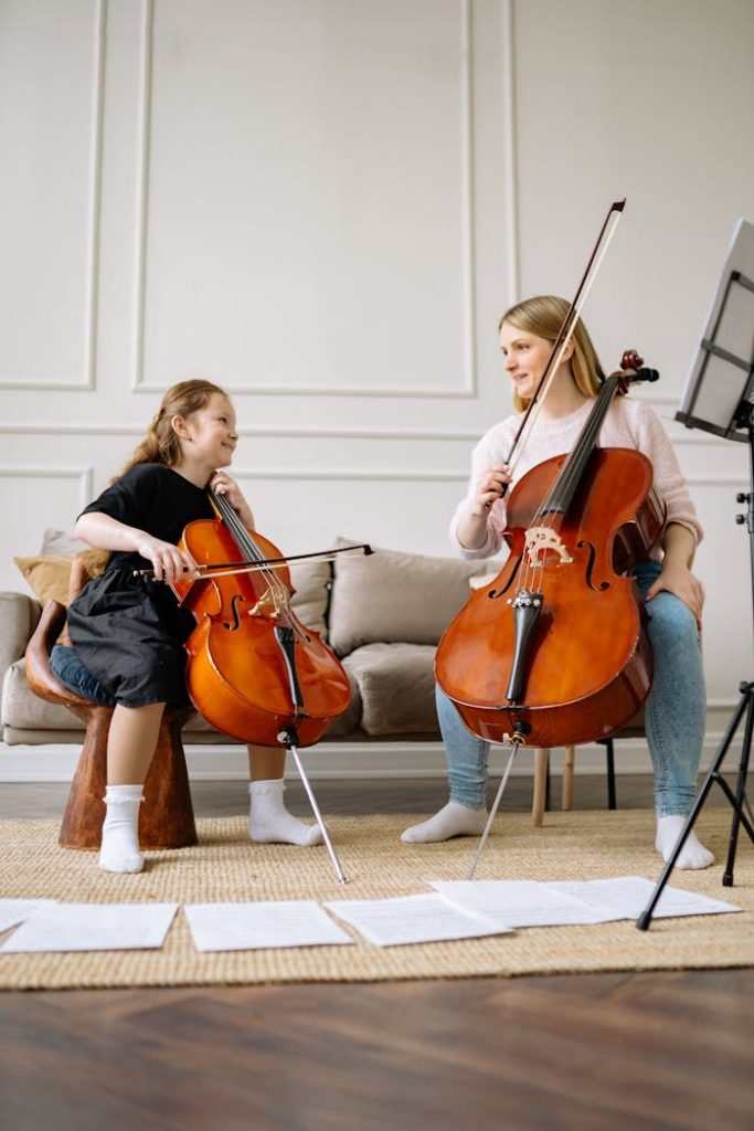 A woman and a child playing cellos together at home, emphasizing music education and bonding.